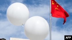 抗议者在中国驻华盛顿大使馆外释放的白色气球在中国国旗旁漂浮。(2023年2月15日)