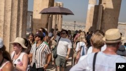 Du khách trong trời nắng nóng ở đồi Acropolis, Athens, Hy Lạp, 13/7/2023 (AP Photo/Petros Giannakouris).