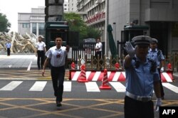 中国警察与保安人员在举行中共三中全会的京西宾馆外执勤时做禁止手势。(2024年7月15日)