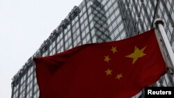 资料照片:中华人民共和国的国旗竖立在普华永道分部所在的北京一座大楼前。 (2014年1月24日)