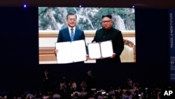 资料照片:媒体在韩国首尔通过大屏幕观看韩国前总统文在寅在平壤与朝鲜领导人金正恩签署协议。(2018年9月19日)