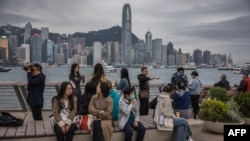 中国大陆游客在香港尖沙咀眺望维多利亚海湾对面的香港岛。(2024年1月17日)