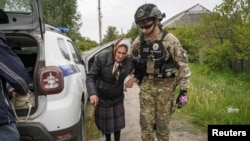 一名警察在俄罗斯袭击乌克兰期间帮助哈尔科夫地区沃夫昌斯克镇居民疏散至哈尔科夫。(2024年5月13日)