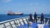 FILE - This handout photo taken April 27, 2021 and received from the Philippine coast guard on May 5, 2021 shows Philippine coast guard personnel aboard their ship BRP Cabra monitoring Chinese vessels anchored at Sabina Shoal, in the South China Sea.