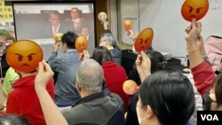 多名参与财政预算案直播会的香港基层市民,高举“嬲嬲”(不高兴)表情纸牌,对俗称“派糖”的纾困措施大幅“减甜”表达不满 (美国之音/汤惠芸)