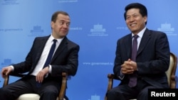 2015年,时任中国驻俄罗斯大使李辉与俄罗斯总理梅德韦杰夫在一场有关西伯利亚力量天然气管道中国段开工的会议上坐在一起。