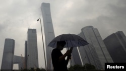 2023年7月12日,中国北京雨天,一名男子行走在中央商务区。(路透社照片)