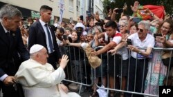 Pope Francis က လစ္စဘွန်းမြို့မှာ ပေါ်တူကီဝန်ကြီးချုပ်နဲ့တွေ့ဖို့အသွား လူထုကို နှုတ်ဆက်နေစဥ်။ (သြဂုတ် ၂၊ ၂၀၂၃)