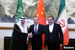 2023年3月10日,伊朗最高国家安全委员会秘书阿里·沙姆哈尼(Ali Shamkhani)(右)在北京举行会谈时同沙特国务大臣、内阁成员和国家安全顾问穆萨伊德·本·穆罕默德·艾班握手, 中共中央政治局委员、中央外办主任王毅居中。