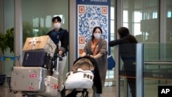 资料照片:2023年4月26日,乘坐国际航班抵达北京机场的旅客走出抵达区。(美联社照片)