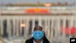 2023年3月3日,北京人民大会堂入口处,一名扮成迎宾员的安保人员站在门口。