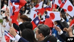 资料照:台湾与日本的国会议员们在台北参加双十节庆典时挥舞台湾与日本旗帜。(2022年10月10日)