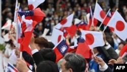 资料照:台湾与日本的国会议员们在台北参加双十节庆典时挥舞台湾与日本旗帜。(2022年10月10日)