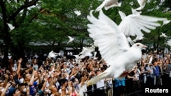 资料照:2023年8月15日,日本东京,在日本二战投降78周年之际,人们在参拜靖国神社时放飞鸽子。(路透社)