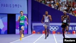 美国短跑选手埃里扬·奈顿(Erriyon Kighton,中)在巴黎奥运会上参加男子200米短跑半决赛。(2024年8月7日)
