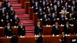 习近平(中)出席2023年3月11号在北京召开的中国第十四届人大第一次会议。