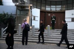 在以色列驻华大使馆外,两名中国便衣警察走向一名路人。之前发生了以色列大使馆雇员在街头被人刺伤的事件。(2023年10月13日)