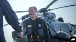 Фото: Канцлер Німеччини Олаф Шольц на фоні гелікоптера Sea King, dpa pool via AP