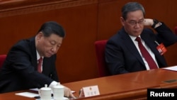 中国领导人习近平和中国总理李强在北京人大会堂出席全国人大会议闭幕式期间习近平在投票。(2024年3月11日)