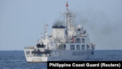 菲律宾海岸警卫队发布照片显示,2023年6月30日一艘中国海警船被指在有争议的南中国海海域骚扰为菲律宾海军运送后勤物资的船只。