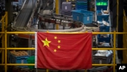 资料照片: 中国国旗悬挂在北京一个网上购物分拣处的货仓(2020年11月11日)