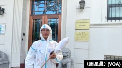 表演“大白”进行抗议的郑伟在中国驻旧金山总领事馆门前。(周星晨)
