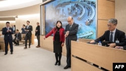 中国常驻联合国日内瓦办事处大使陈旭(右二)准备在联合国人权理事会对中国人权状况进行的定期审议会上发言前看手表。(2024年1月23日)