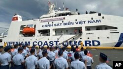 菲律宾海岸警卫队队员挥舞越南和菲律宾国旗欢迎越南海岸警卫队船只CSB 8002抵达马尼拉港。(2024年8月5日)
