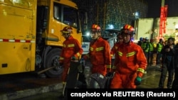 中国齐齐哈尔消防员手持救援工具参加在齐齐哈尔中学体育馆房顶塌陷后的搜救行动。(2023年7月24日)