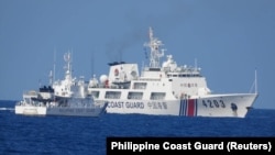 菲律宾海岸警卫队发布照片显示,2023年6月30日一艘中国海警船被指在有争议的南中国海海域骚扰为菲律宾海军运送后勤物资的船只。