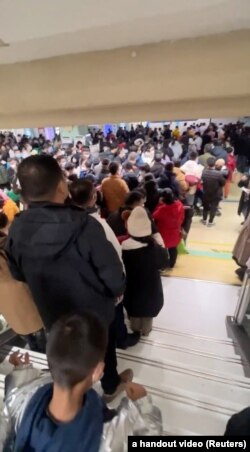 视频截图显示北京西城区儿童医院候诊室里挤满了等候看病的儿童和家长。(2023年11月27日)