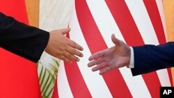 资料片:美国总统拜登与中国国家主席习近平在印度尼西亚巴厘岛20国集团峰会期间举行面对面会谈前伸手握手。(2022年11月14日)