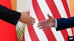 资料片:美国总统拜登与中国国家主席习近平在印度尼西亚巴厘岛20国集团峰会期间举行面对面会谈前伸手握手。(2022年11月14日)