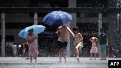 在热浪中,香港儿童在一处喷泉戏水乘凉。(2023年7月9日)