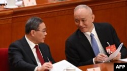 中国总理李强(左)与中共中央政治局常委蔡奇在北京人大会堂的全国人大会议开幕式上。(2024年3月5日)
