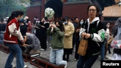 中国年轻人到北京一间寺庙烧香祈福。(2023年4月22日)
