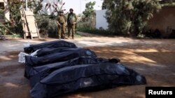 以色列士兵在以色列南部Kibbutz Kfar Aza地区守护着被巴勒斯坦武装分子杀害的以色列平民的遗体。(2023年10月10日)