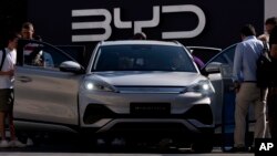 တရုတ်ပြည်တွင်းထုတ် BYD လျှပ်စစ်ကားကို ဝယ်ယူလိုသူတွေ ကြည့်ရှုစစ်ဆေးနေစဥ်။