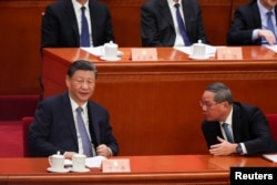 资料照:中国领导人习近平与总理李强在北京人大会堂出席全国政协会议开幕式时交谈。(2024年3月4日)