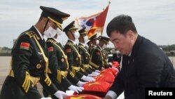 资料照片:2022年9月16日,中国驻韩国大使邢海明在仁川国际机场举行的交接仪式上用中国国旗盖住装有中国士兵遗骸的棺木。(路透社照片)