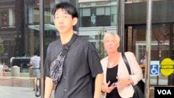 因涉嫌暴力威胁亲民主人士而被美国起诉的中国留学生吴啸雷在首次预审会议结束后,与他的律师杰西卡.海吉斯一起走出位于波士顿的联邦地区法院大门。(2023年7月27日)