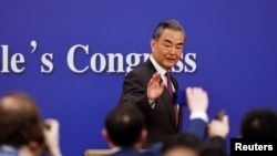 中国外交部长王毅出席全国人大会议记者会,离开时向在场中外媒体记者挥手。(2024年3月7日)