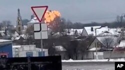In this handout photo taken from validated UGC video, flames are rising from the scene of a warplane crashed at a residential area near Yablonovo, Belgorod region, Jan. 23, 2024.
