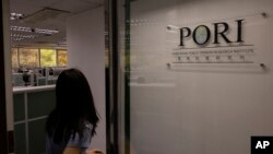 香港民意研究所的一名雇员走进大门。(2023年6月21日)