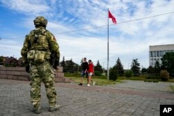 资料照:一名俄罗斯士兵在乌克兰南部赫尔松州的一处纪念广场上站岗。(2022年5月20日)
