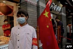 中国国旗假日期间,北京南锣鼓巷胡同里的一名治安员在值勤。(2022年10月3日)