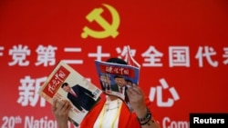 一名记者在北京一家酒店的中共二十大新闻中心阅读有着中国领导人习近平照片封面的杂志。(2022年10月19日)