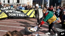 英国抗议民众在伯明翰市保守党星期天会议场馆外面焚烧虚假的能源账单(2022年10月1日)
