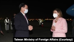 台湾外交部长吴钊燮(左)在台北松山机场迎接美国会众议院议长佩洛西。(2022年8月2日)