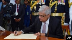 2022年7月21日,斯里兰卡新当选总统拉尼尔·维克勒马辛哈(Ranil Wickremesinghe)在科伦坡宣誓就职后签字。照片由斯里兰卡总统办公室发布,美联社提供。